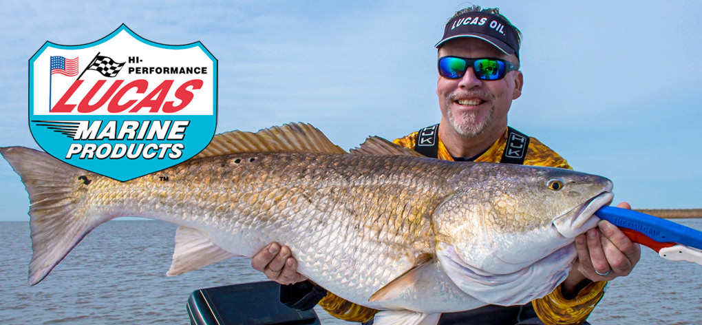 Photo of Mark Davis wearing a Lucas Oil visor holding a large fish. The Lucas Oil Marine Products logo is displayed.